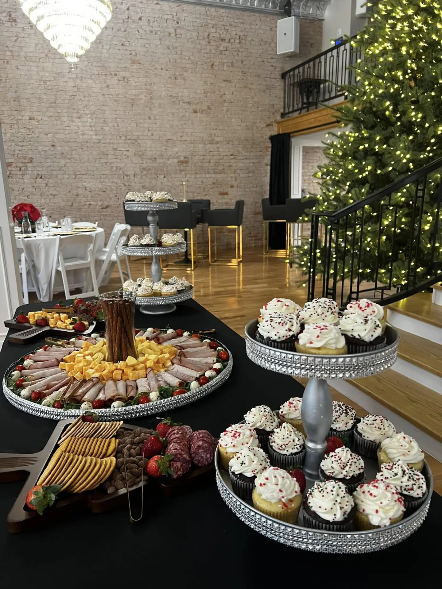 Holiday reception with meat and cheese platter and cupcake stands